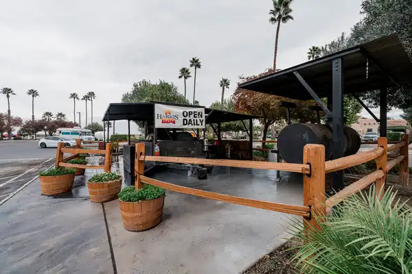 Harris BBQ outdoor smoker area with planters and fencing