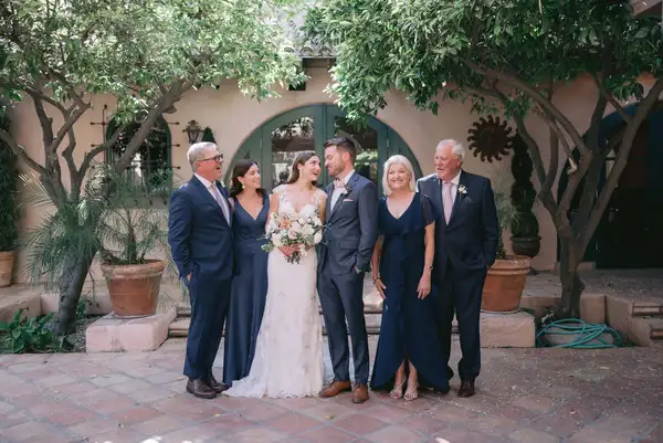 Bride and groom posing with their families