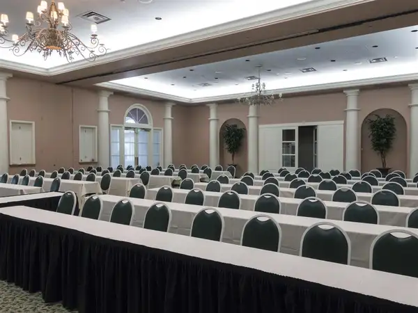 Meeting room with dozens of seats at long tables