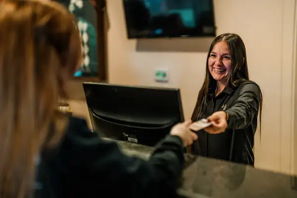 Hostess handing checkin information to customer