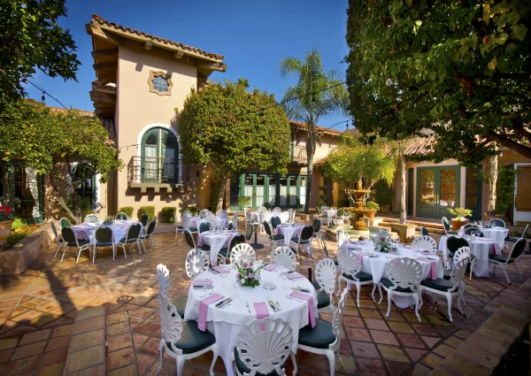 Round banquet tables set in the sunny outdoor courtyard