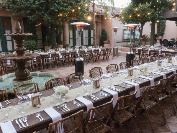 Long dinner tables set beside the courtyard fountain
