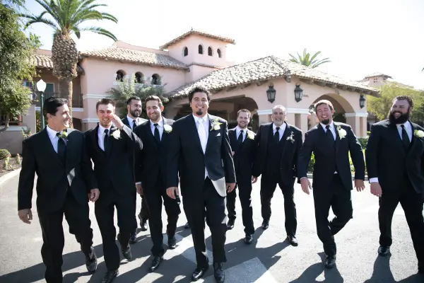 Groom and groomsmen walking in front of the hacienda-style hotel