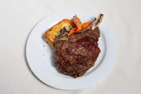 Prime Steakhouse bone-in ribeye with vegetables